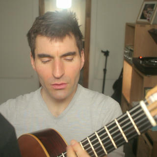 A thumbnail from the music video featuring me playing the guitar and signing. Une vignette du clip vidéo dans laquelle je joue de la guitare et chante.