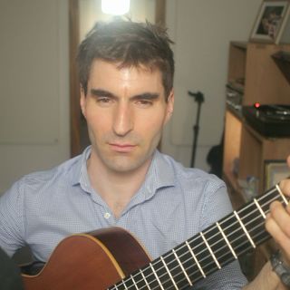 A thumbnail from the music video featuring me playing the guitar and signing. Une vignette du clip vidéo dans laquelle je joue de la guitare et chante.